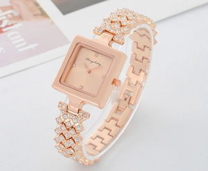 Detail of a rose gold quartz watch with a diamond-encrusted geometric hollow bracelet