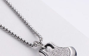 Macro detail of silver stainless steel Evil Eye pendant with textured granular finish