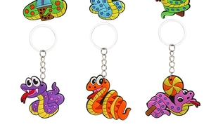 Detail view of colorful PVC cartoon snake keychains with bubble tea and lollipop accessories