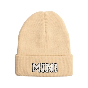 Detail of beige knit beanie showing textured ribbing and MINI towel embroidery