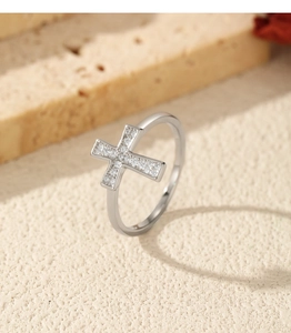 Detailed view of silver cross ring featuring sparkling moissanite stones and polished band