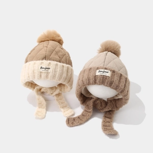 Winter knit baby hats with pom-poms and ear flaps in khaki and beige tones