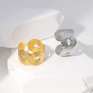 Detailed view of wide open rings with metallic woven texture in gold and silver finish