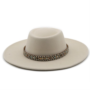 Close-up of beige flat top wool hat featuring a colorful geometric woven ethnic band
