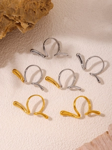 Detailed view of abstract curved bicolor rings in gold and silver on stone decor