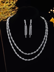 Detail of silver layered necklace and fringe earrings set with sparkling rhinestones
