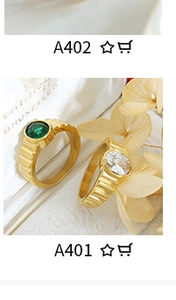 Close-up of vintage gold rings with green and white gemstone inlays and textured bands