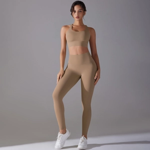 Detail of high-waist yoga leggings and sports bra set in camel brown elastic fabric