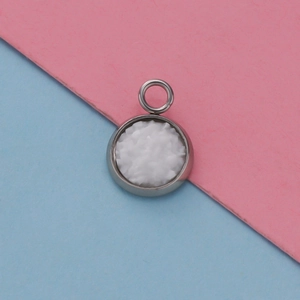 Macro shot of 12mm silver stainless steel round pendant with textured white inlay