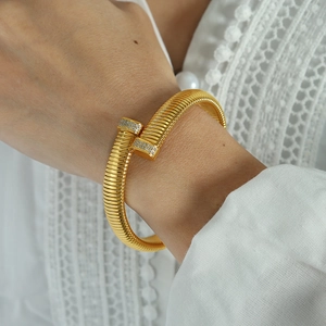 Elegant gold vertical textured open cuff bracelet with zircon accents on female wrist