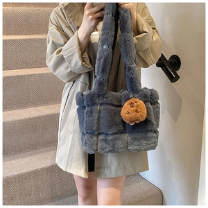Detailed view of grey plush tote bag with a cute bear charm and quilted pattern