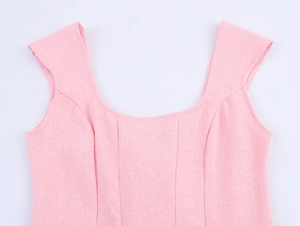 Detail of pink square neck dress featuring thick textured fabric and princess seam stitching