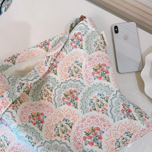 Dettaglio della stampa mandala floreale su borsa in tela di cotone beige con etichetta