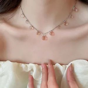Collier en perles de résine rose avec chaîne argentée en acier sur modèle féminin