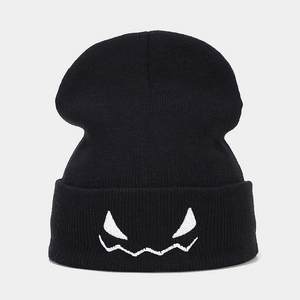 Close-up of spooky monster face embroidery on black cuffed winter beanie hat
