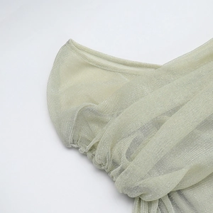 Detailed macro view of champagne gold mesh fabric with metallic shimmer and pleats