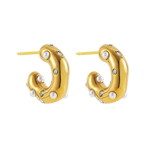 Detail of C-shaped gold earrings featuring white pearls and sparkling zircon stones