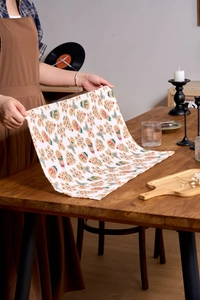Detail einer Weihnachtsserviette mit Lebkuchenmann-Druck auf einem rustikalen Holztisch