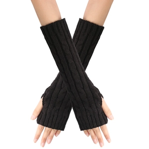 Close-up of black cable-knit long fingerless gloves showing detailed wool texture