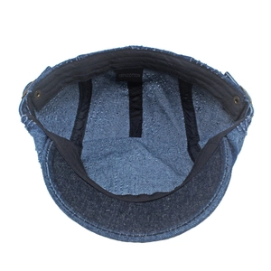 Macro shot of 100% cotton label and black lining on a dark blue washed denim newsboy cap