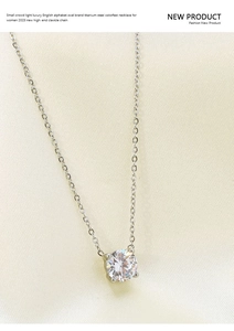 Close-up of titanium steel necklace featuring a single round cubic zirconia on beige silk