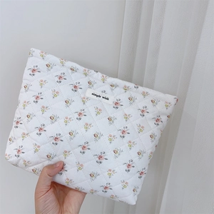 Detailed close-up of quilted floral cotton makeup bag with pastel pink flower patterns