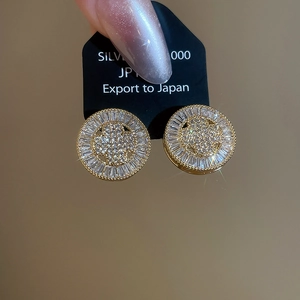 Macro shot of gold-plated silver round stud earrings encrusted with zircon crystals