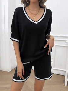 Women's black knit lounge set featuring V-neck short sleeve top and shorts with white stripes