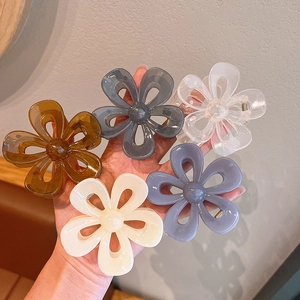 Handheld display of five camellia flower hair claws in assorted jelly-tone acrylic colors