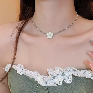 Detail of silver floral pendant necklace with a white zircon center on a female model