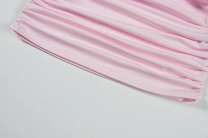 Gros plan sur le tissu froncé rose montrant la texture élastique et les coutures latérales