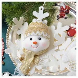 Close-up of plush snowman head ornament with gold striped knit hat and white snowflake