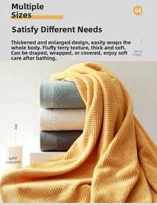 Detail of four thick cotton bath towels with textured waffle pattern in neutral colors