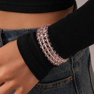 Close-up of three-layered pink faceted glass bead bracelet worn on a female wrist