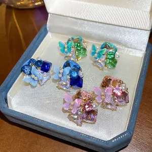 18k gold plated stud earrings set with butterfly crystals and pearls on velvet