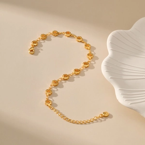 Detailed shot of 18K gold plated hollow floral bracelet with lobster clasp and chain