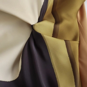 Macro detail of elegant printed silk dress fabric with golden and brown satin texture