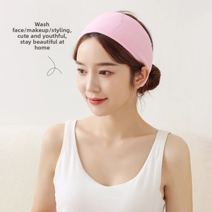 Pink absorbent facial headband for skincare and makeup rituals on a female model