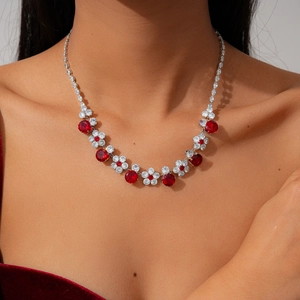 Detailed close-up of a floral zircon necklace set with ruby-red stones and silver base