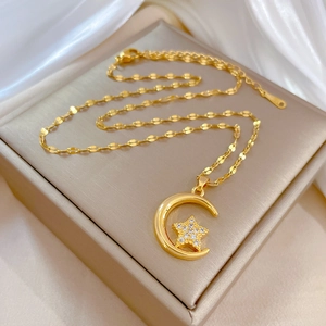 Collier en acier titane avec lune et étoile et zircons sur une boîte à bijoux beige