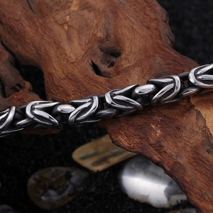 Makroaufnahme der 8mm Edelstahl-Byzantiner-Gliederkette auf strukturiertem Holz