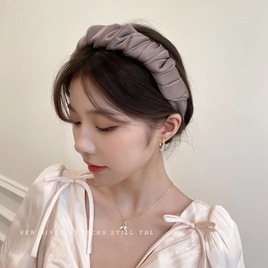 Elegant wide pleated hairband in dusty pink satin on model with necklace and pearl earrings
