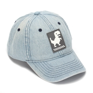 Macro view of blue denim cap featuring a pixel dinosaur patch and reinforced stitching