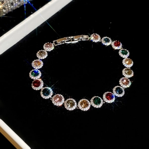 Détail d'un bracelet tennis coloré avec pierres rondes et halo de zircon sur velours noir