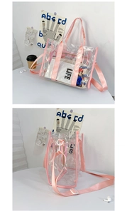 Detail of transparent PVC tote bag with pink webbing handles and adjustable shoulder strap