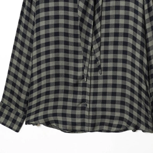 Women's black and green plaid shirt featuring long sleeves and premium button details