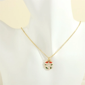Detailed close-up of a festive Christmas wreath pendant on a gold chain necklace for women