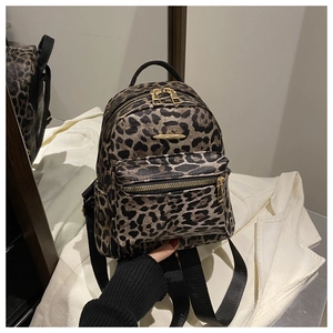 Detail of trendy leopard print backpack with gold metal zippers and black straps