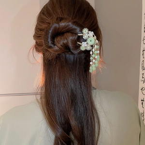 Detail einer chinesischen Haarnadel mit grünen Jadeperlen und Perlenquasten am Dutt