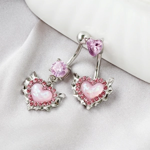 Detailed view of silver heart navel rings with pink opal and purple zircon on silk